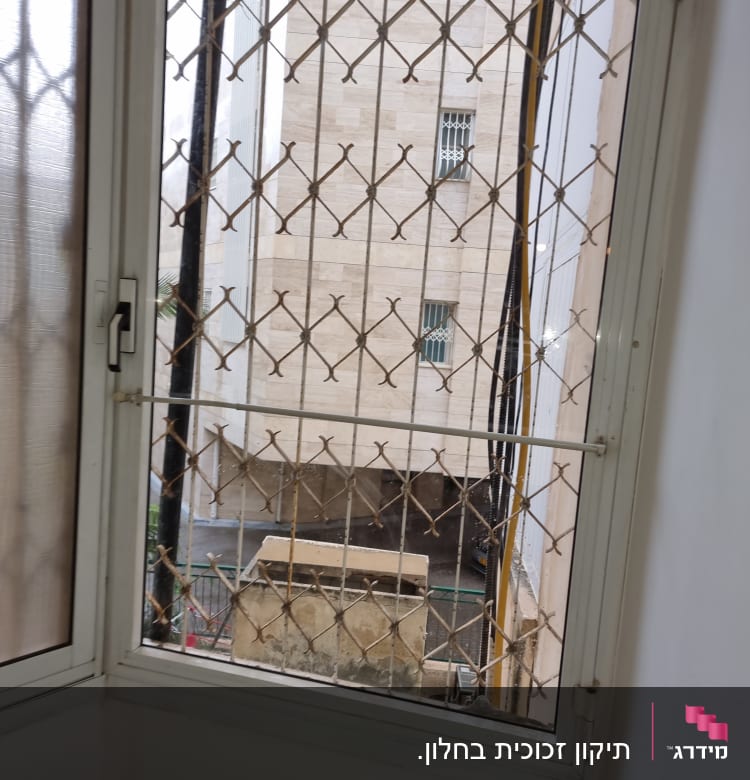 חלון זכוכית עם סורגי מתכת חיצוניים